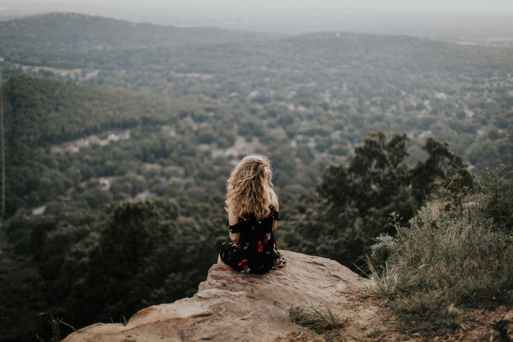 Financial independence my financial health - Woman sitting on edge of cliff