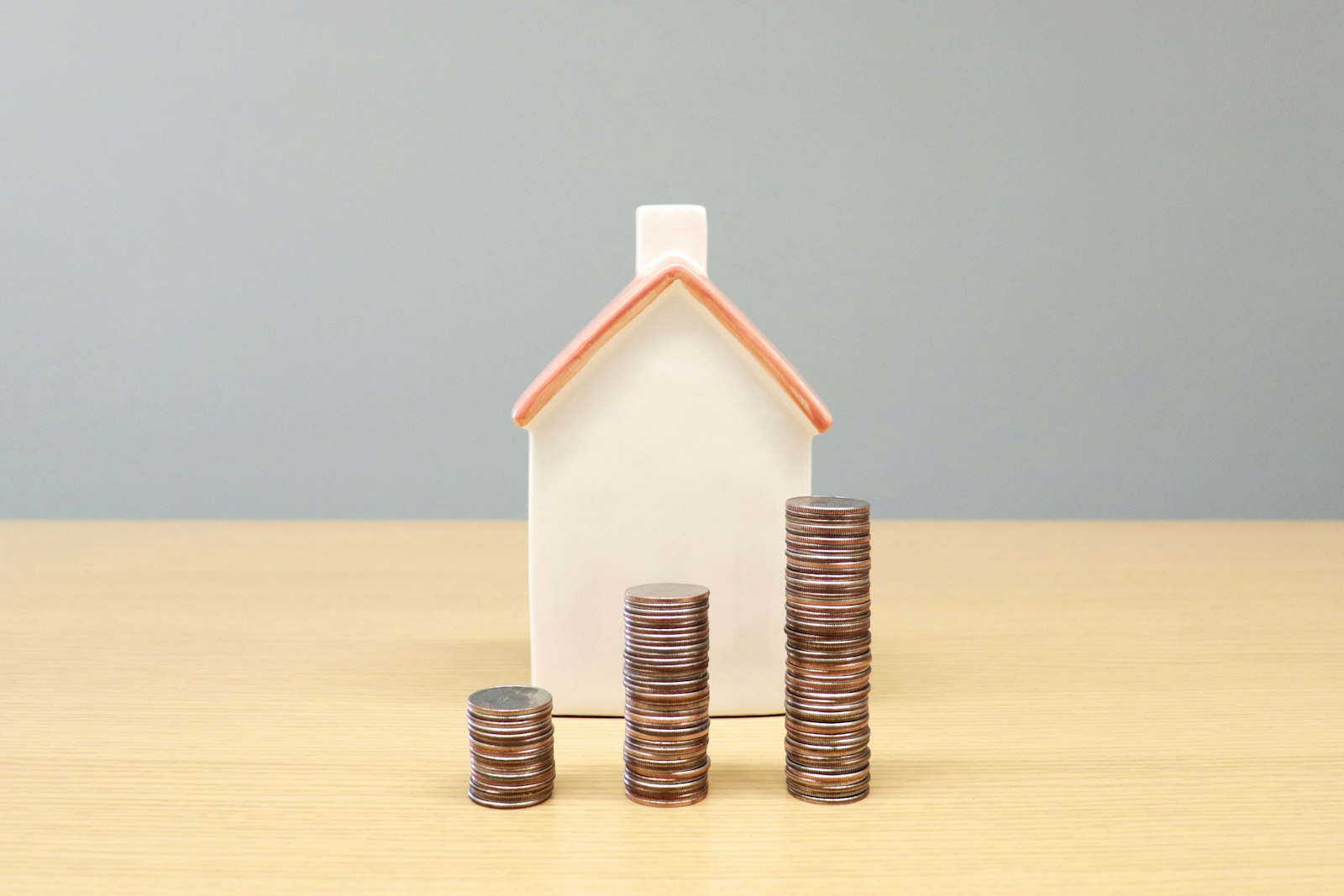 house model and coins representing mortgage and inflation pressure