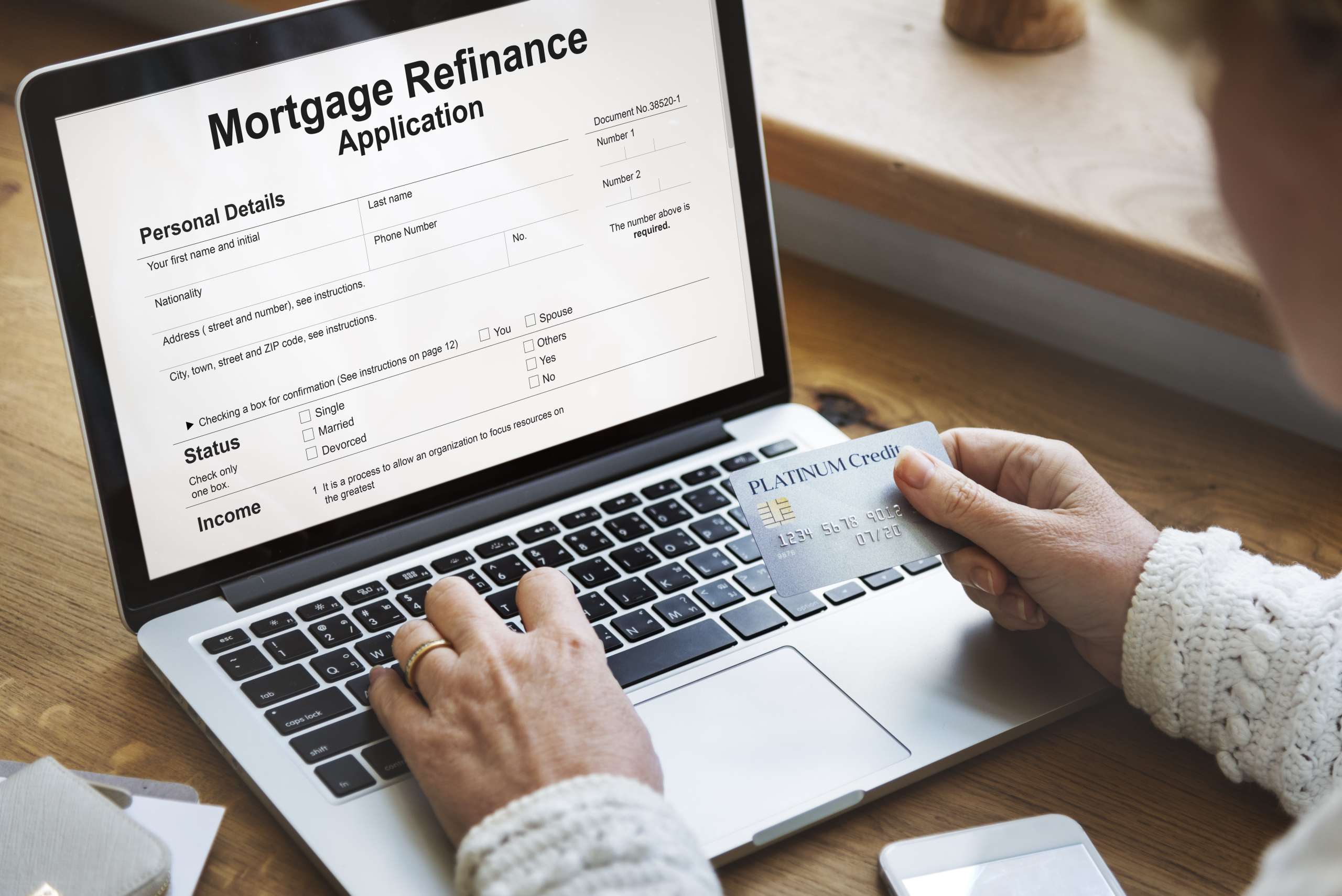 Couple reviewing mortgage refinance and debt consolidation paperwork at home